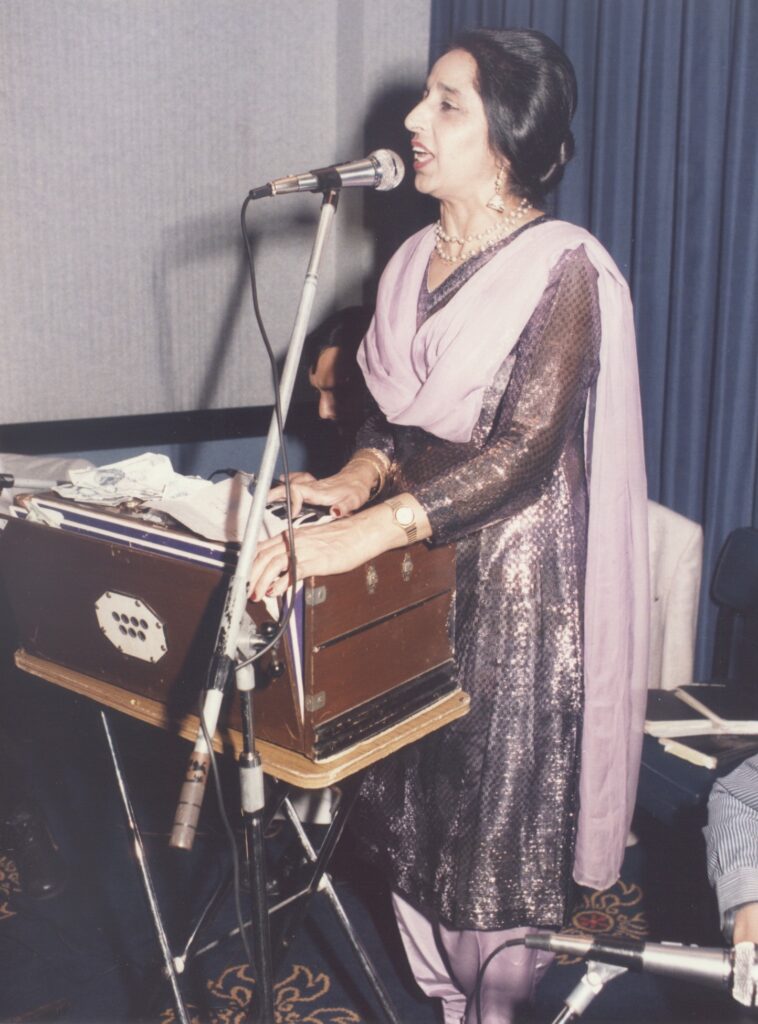 Mohinder Kaur Bhamra singing and playing harmonium, from the In Sheep’s Clothing feature